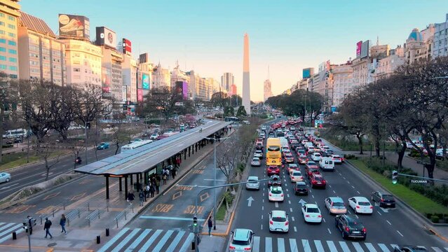 Bottleneck heavy traffics at major thoroughfare, 9 de Julio Avenue in the city centre of Buenos Aires during off-work rush hour, cars stopping and waiting at the traffic light, aerial shot from above.