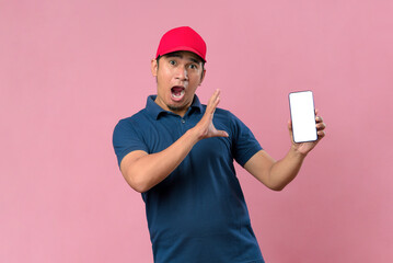 Portrait of a excited happy young delivery man showing display of mobile phone.