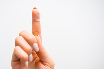 Contact lenses on the tip of womans finger on the white background with copy space. Improvement in...