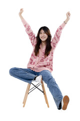 Joyful Young Woman: A young woman sits on a stool, arms raised in triumph, radiating happiness and...
