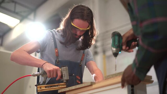 Team of professional carpenter working together in the furniture factory. 