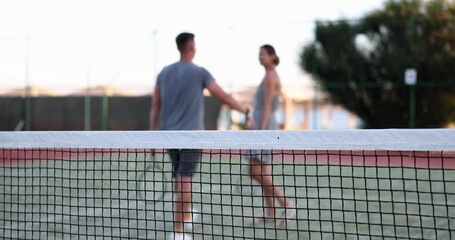 Couple leaves playground after playing tennis