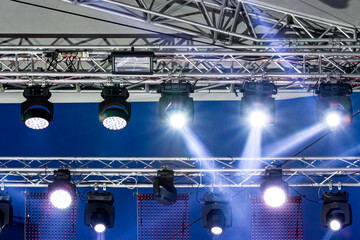 lighting equipment high above an outdoor concert stage. stage spotlight with light beams.