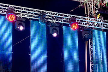 bright spotlights illuminate outdoor concert stage. row of spotlights on stage rigging.
