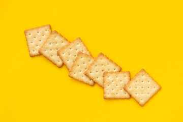 Dry cracker cookies on yellow background.