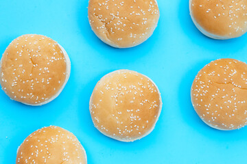 Hamburger buns with sesame on blue background.