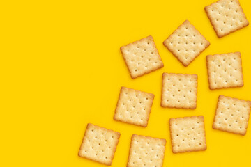 Dry cracker cookies on yellow background.
