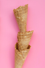 Empty ice cream cone on pink background.