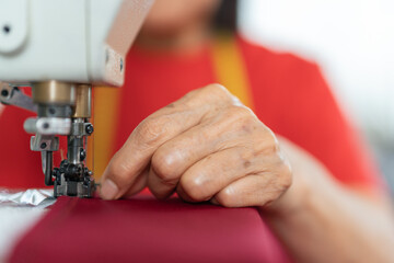 Hands of a woman sewing in a workshop