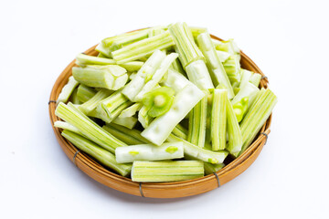 Moringa oleifera cut in pieces in bamboo weave plate on white background.