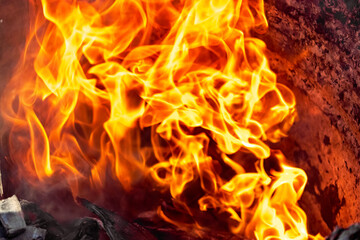 Burning fire close up. Bright orange and red flames on a dark background. Open flame heating....