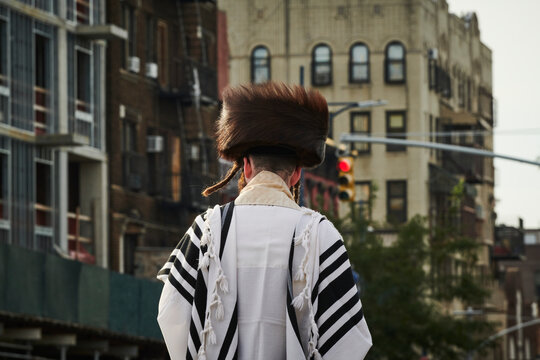 a hasidic jewish man walking down the street in williamsburg brooklyn