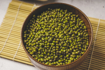 fresh mung beans in ceramic dishes against a white stone background, coppy space.
