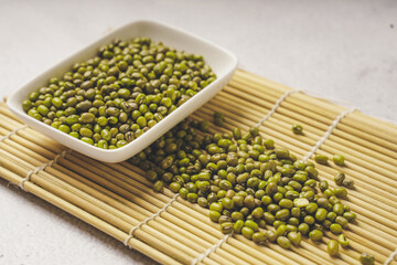 fresh mung beans in ceramic dishes against a white stone background, coppy space.