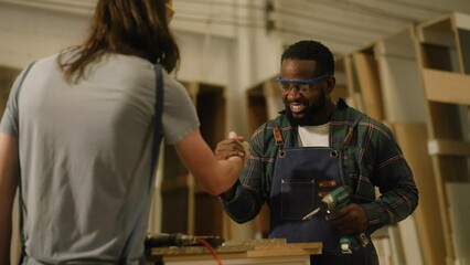 senior carpenter teaching apprentice standing at table in workshop,Carpenter working on wood craft at workshop to wooden furniture in workshop.profession,carpentry, woodwork and people concept.