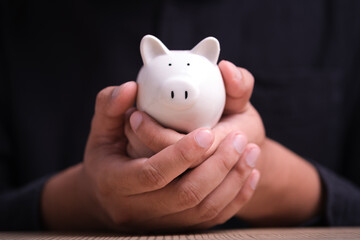 Businessman hand holding piggy bank. Concept of saving money wealth and financial concept,...