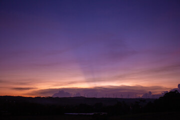 Silhouettes of Wind turbines farm on mountains in rural areas with Colorful scenery skyline background.