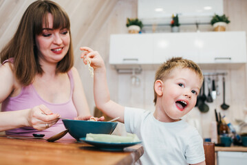 Obraz na płótnie Canvas Little child refuses to eat pasta in the kitchen