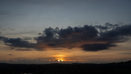 Morning view at morning sunrise, clouds in orange crimson colors. Silhouettes of houses roofs, trees, and a monastery on the hill. Colorful scenery skyline background.