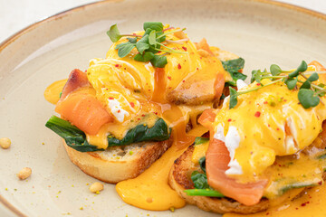 Portion of eggs benedict toast with salmon and herbs breakfast