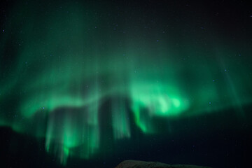 Aurora borealis in the starry night sky over the lake