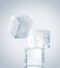 Natural clean ice cubes on white background stacked unbalanced vertically.