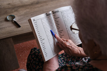 senior woman spending retirement time playing word search at home