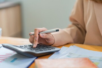 Fototapeta premium Close-up of female accountant or banker making calculations. Savings, finances, and economy concept