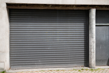 Fototapeta na wymiar metallic gray curtain of facade store closed roller grey garage gate access