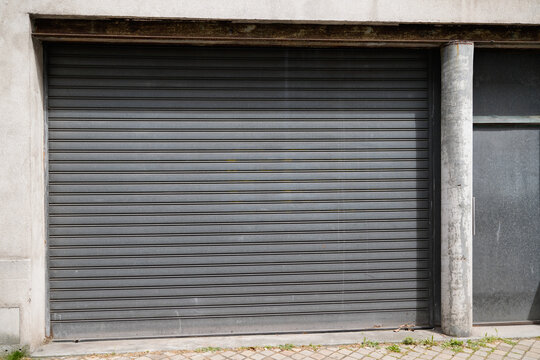 metallic gray curtain of facade store closed roller grey garage gate access