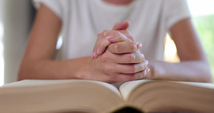 Christian joined hands in prayer for blessings of Jesus sitting on bible