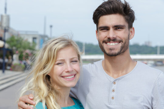 young couple smiling and posing for picture