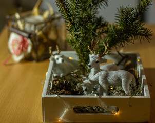 Рождественская декорация с елью, белыми оленями  в загоне