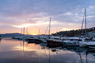 Sailboats at Tarabya yacht marina in Istanbul. Reflection of yachts and hotel. Blue sky and natural white clouds.	