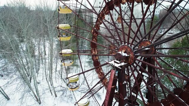 Rusty Ferris Wheel and winter Pripyat city in Chernobyl exclusion zone.