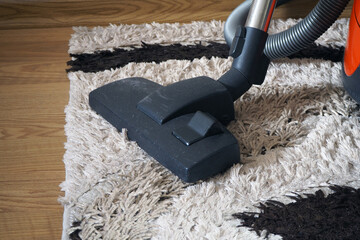 Vacuum cleaner standing on carpet at home.