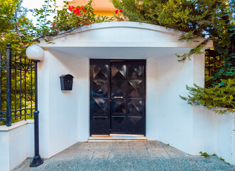 A contemporary house entrance, with a black painted solid iron door. Athens, Greece.