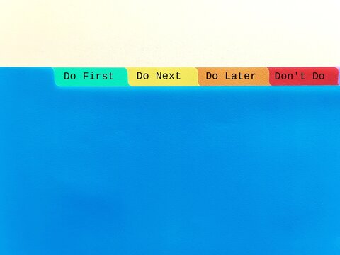 Document folder on copy space blue background with tag DO FIRST DO NEXT DO LATER DON'T DO, concept of time management skills, knowing priority of tasks, difference between important and urgent tasks