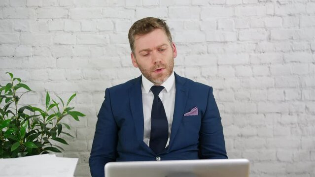 A businessman having a bad day at work in his office with laptop