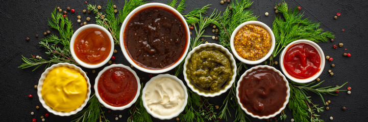 Different types of sauces in bowls with seasonings banner, rosemary and dill, thyme and and peppercorns, top view, copy space