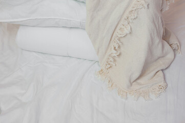 Obraz premium stack of white pillows and blankets lies on the bed on a white sheet on top, covered with a blanket