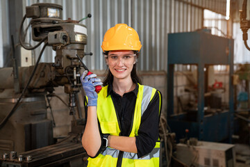 Portrait of female automation engineer standing and looking camera in industrial factory. 