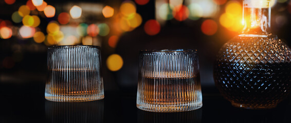 a glass of whiskey on wood bar, soft focus.	