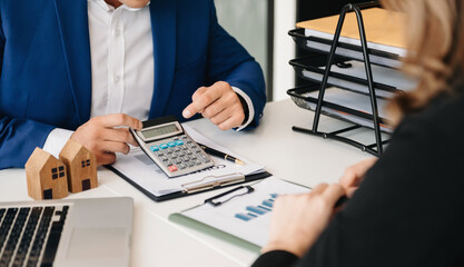 Real estate broker agent presenting and consult to customer to decision making sign insurance form agreement, home model, concerning mortgage loan offer