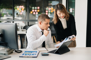 Businessman leading team meeting and using tablet and laptop computer with financial in office