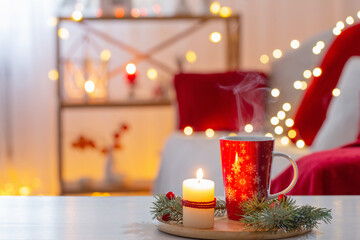 cup of hot drink with christmas decorations in white and red colors at home