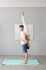 The couple is doing yoga in the studio. Partner support. . High quality photo