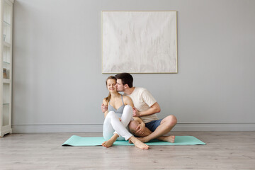 Couple of people sit on the carpet in the studio and relax after yoga class. High quality photo