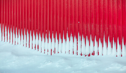 Red galvanized sheet covered with snow