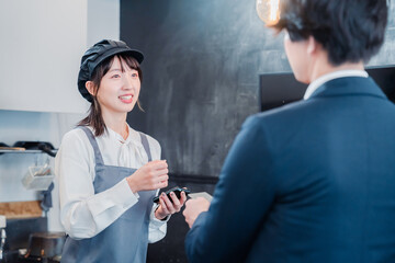 カフェでクレジットカード決済をする男性客